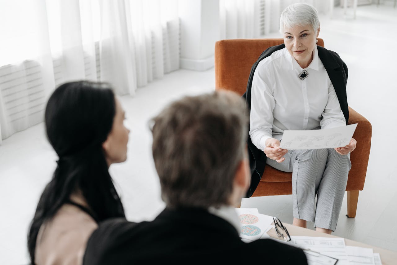 The Art of Drawing Readers In: Your attractive post title goes here Professional advisor discussing documents with a couple in a modern office setting.
